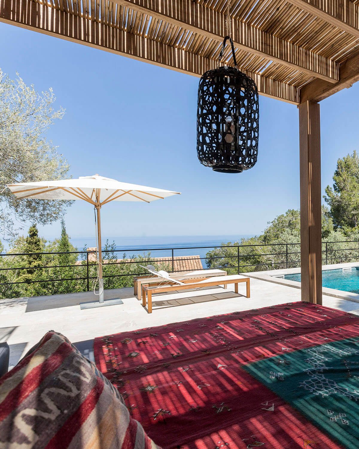 Blick von Liegefläche im orientalischen Design zum modernen Pool der Ferienwohnung